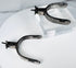 Decorated steel cowboy spurs with silver overlays, strap slots, and aged surface