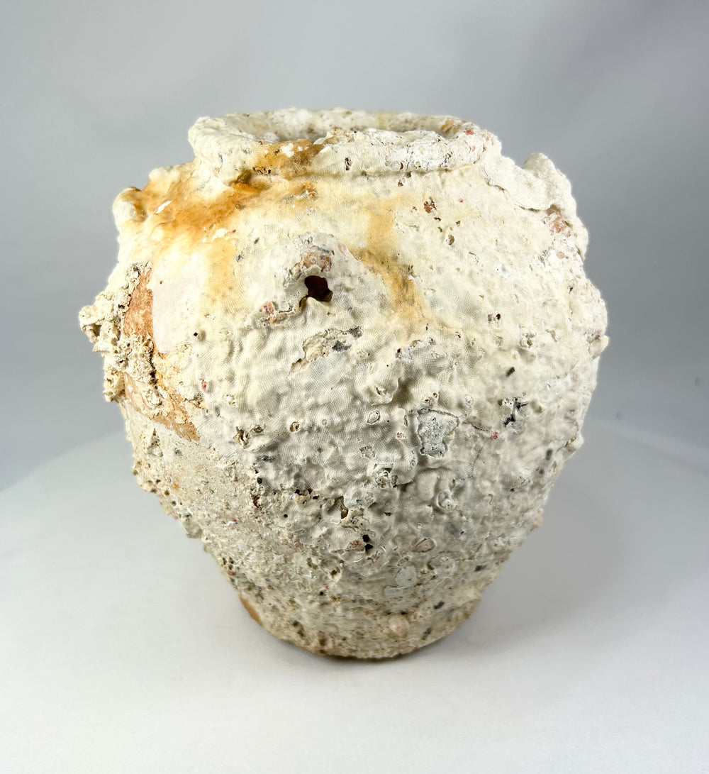 Large terracotta storage jar from a Song Dynasty shipwreck, covered in sea encrustations with broad body and narrow neck