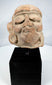 Pre-Columbian sculptural head fragment mounted on a modern display stand