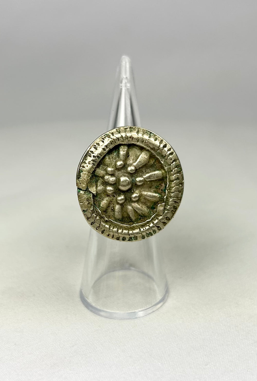 European 1800s ring with tapered band and ornate raised rosette floral centerpiece.