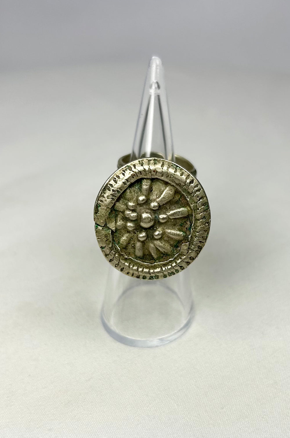 Victorian-era silver-toned ring with central rosette motif and intricate beaded edging.