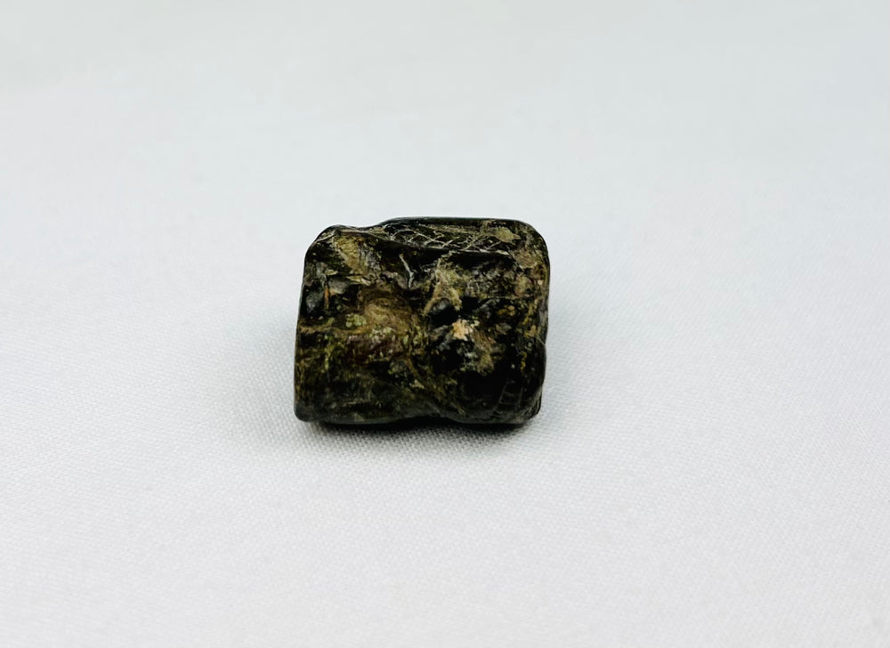 Early Egyptian protective amulet bead with incised snake patterns and pendant perforation