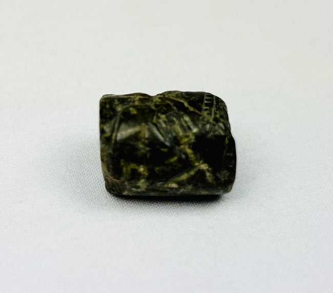 Stone cylinder amulet with serpent-like carvings worn as ancient Egyptian jewelry