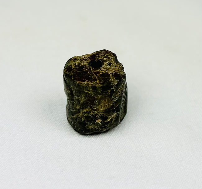 Small carved stone amulet from Egypt featuring symbolic snake forms and worn surface