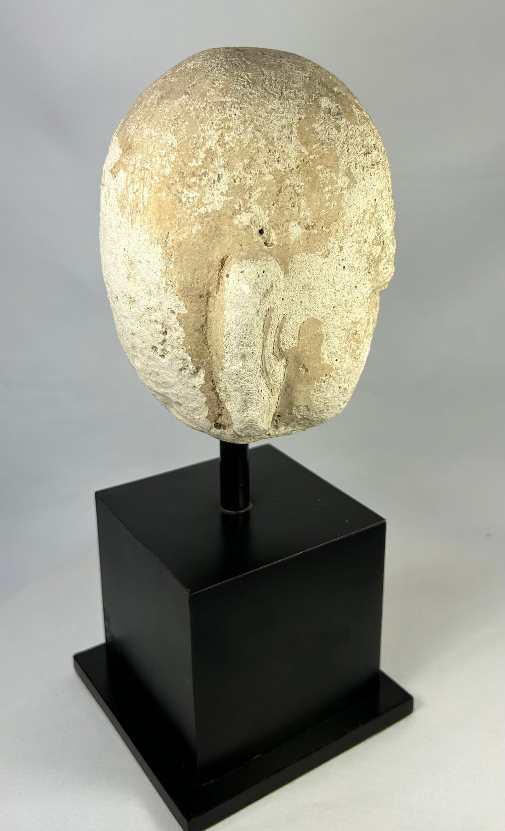 Detailed macro image of Southeast Asian stone Buddha sculpture, 13th–14th century head fragment with meditative features and soft carving lines.