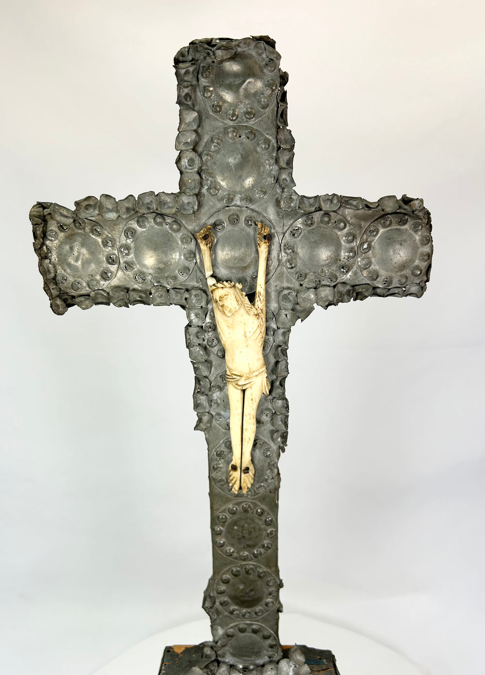 Gilded Christ figure on aged bronze cross — close frontal view.