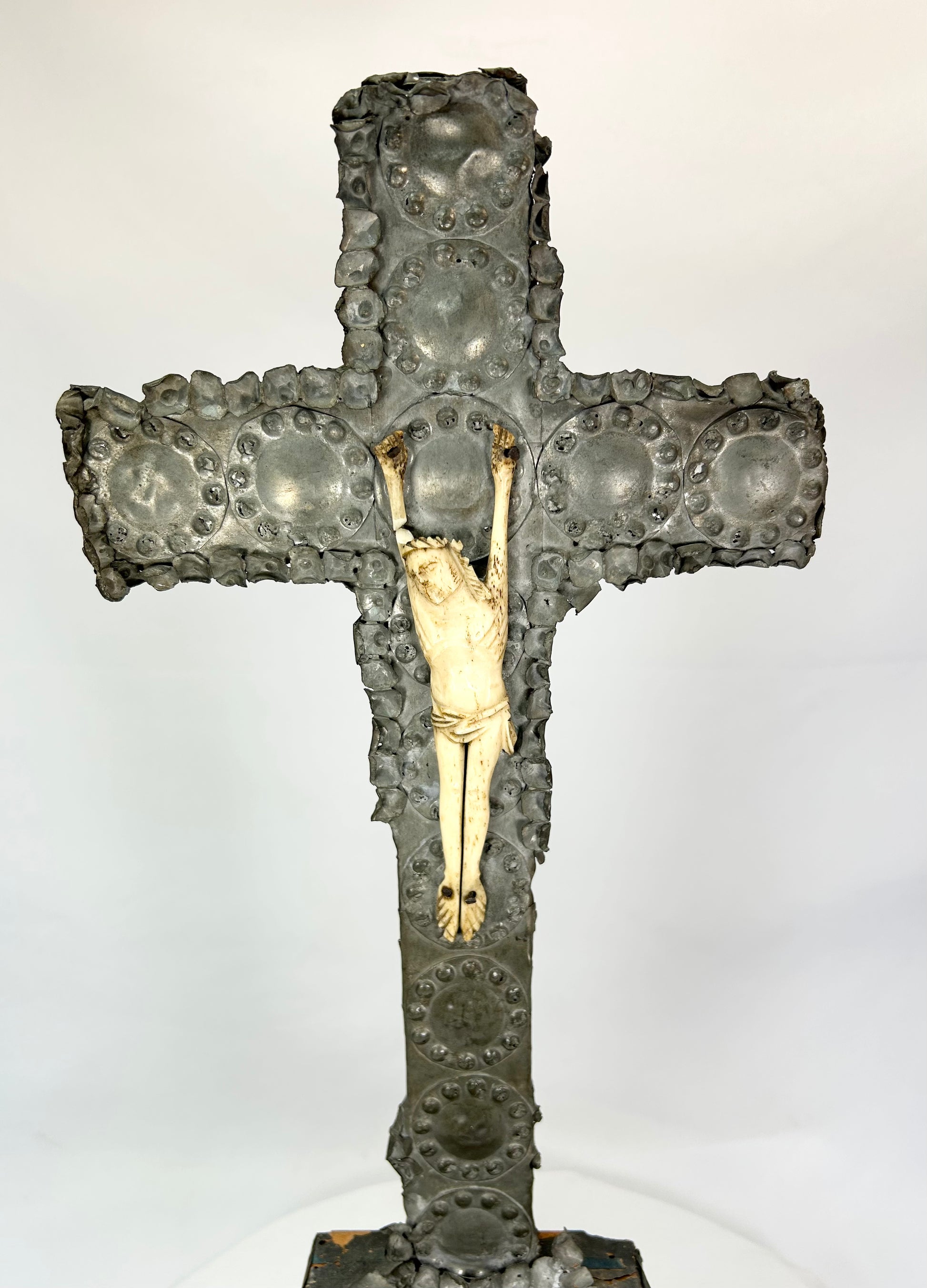 Gilded Christ figure on aged bronze cross — close frontal view.