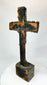 Bronze cross relic — back view on display stand revealing natural patina and form