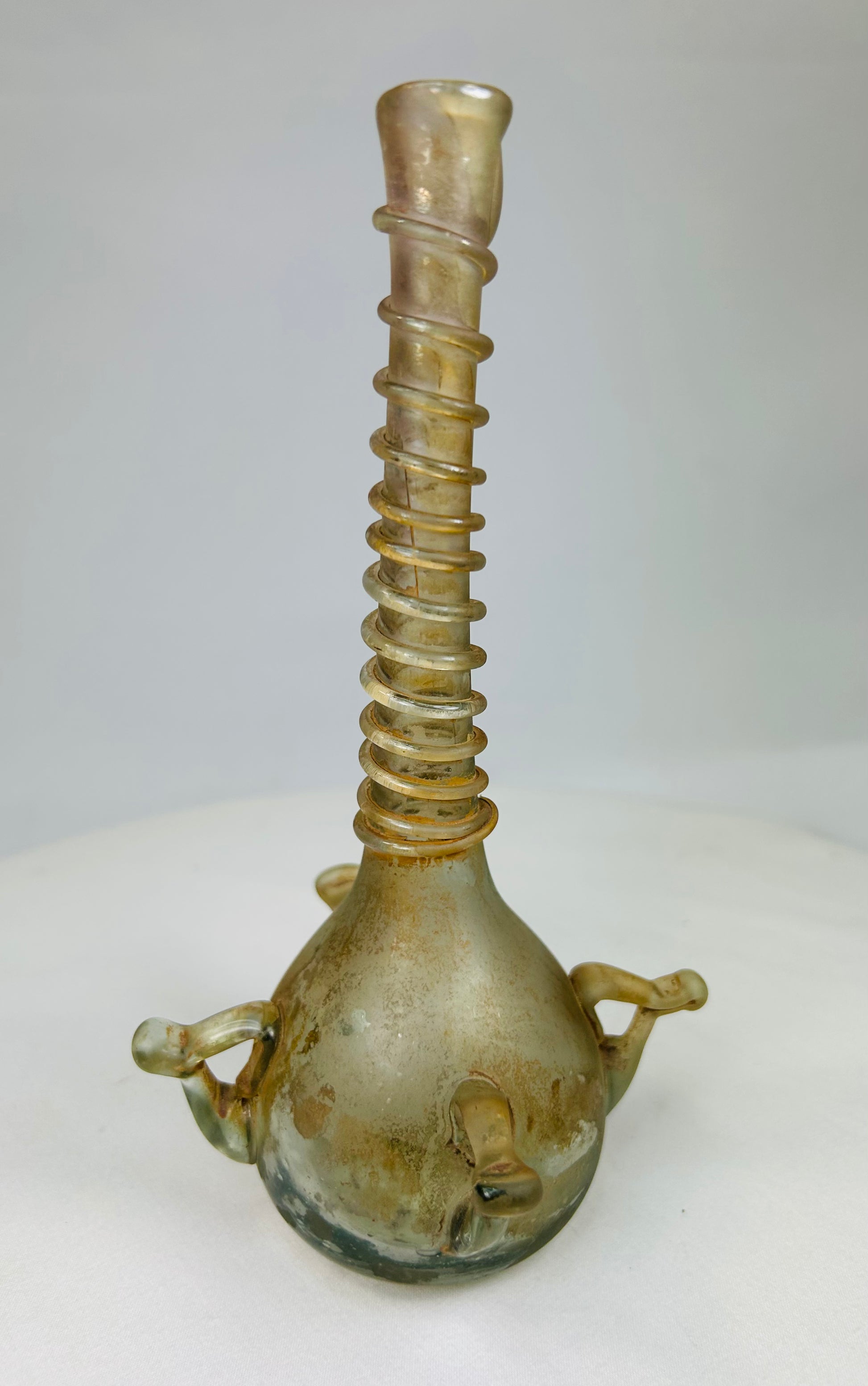 Right side of antique Islamic glass bottle featuring ribbed neck and minor surface wear from antiquity.