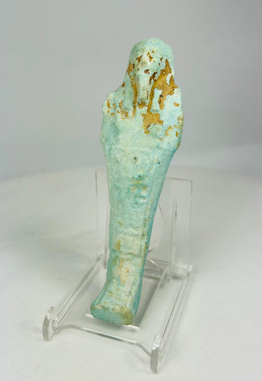 Slight left view of turquoise-blue Egyptian ushabti showing detailed mummiform body and carved inscriptions.