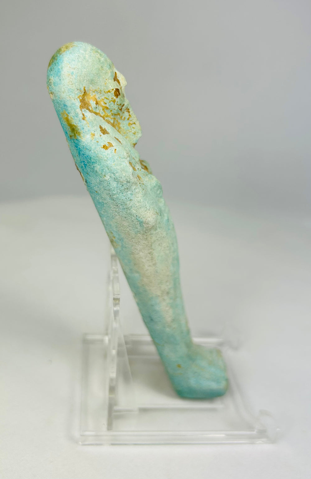 Right side of turquoise-glazed faience ushabti showing ancient surface wear and burial patina.