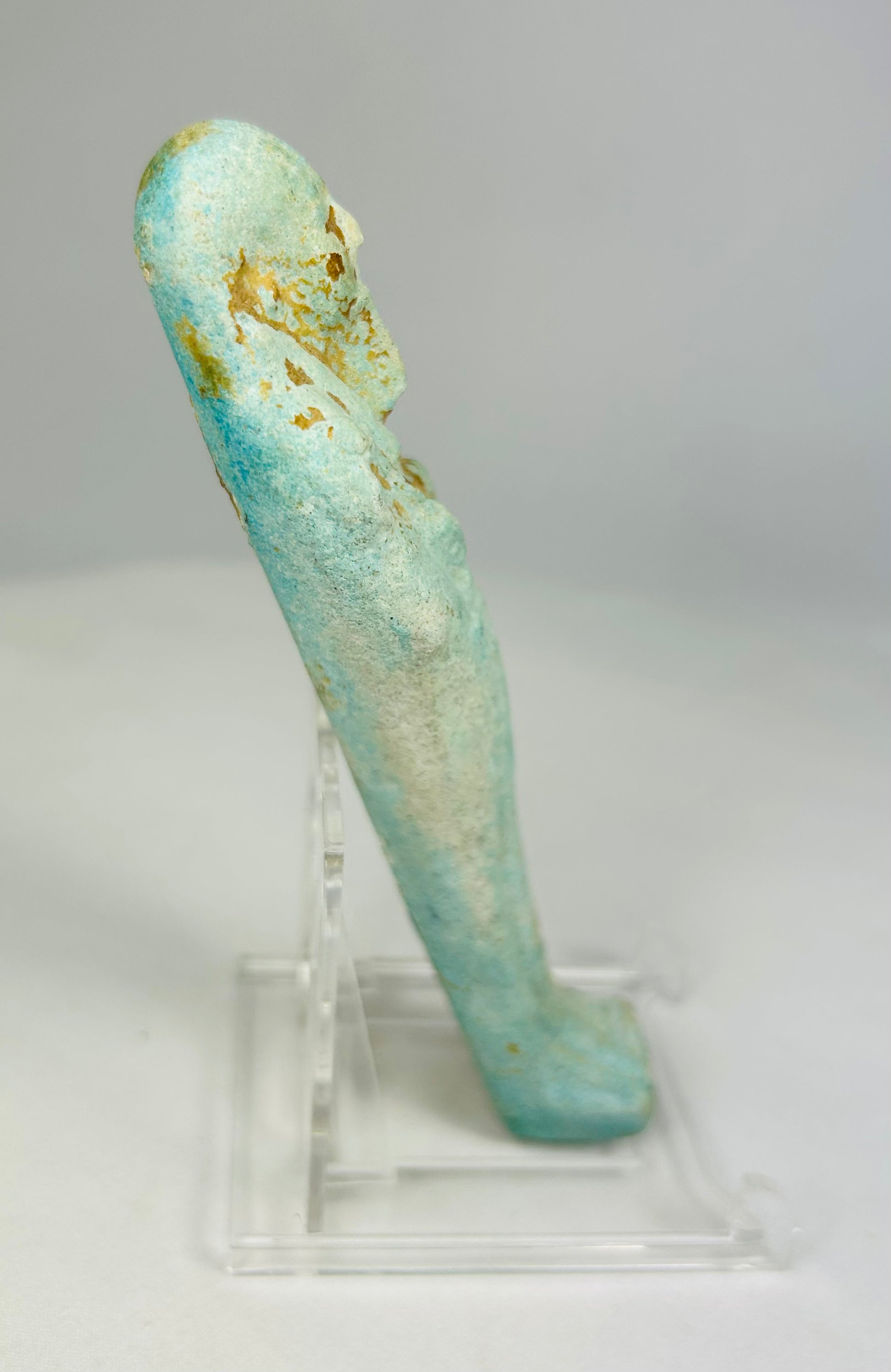 Right side of turquoise-glazed faience ushabti showing ancient surface wear and burial patina.