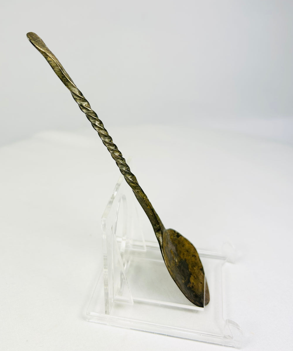 Right side profile of ancient bronze spoon displaying corrosion and natural verdigris from age.