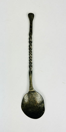 Overhead back view of ancient bronze spoon showing reverse side of bowl, twisted handle, and aged green patina from antiquity.