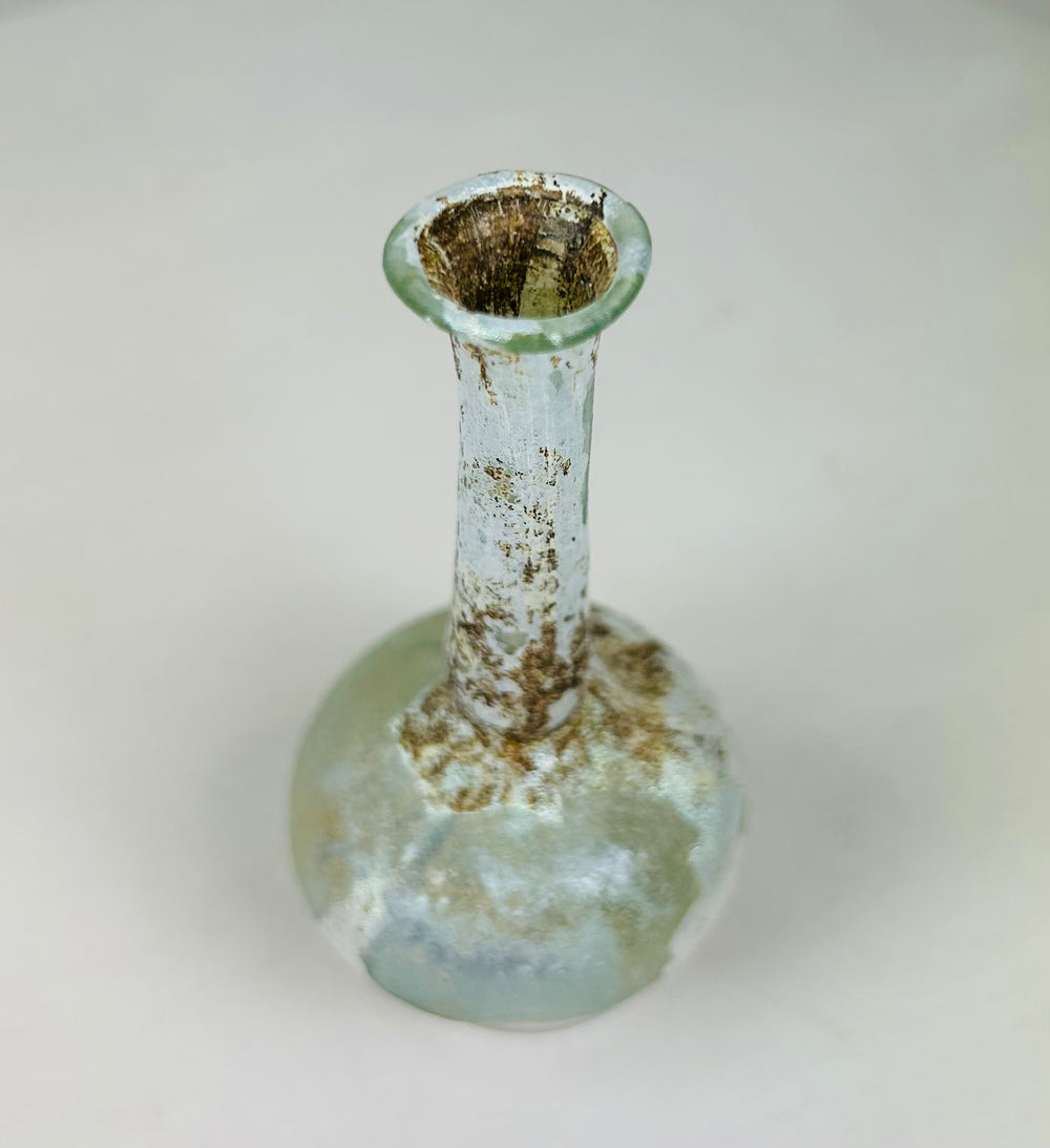 Overhead view of Roman glass bottle revealing narrow mouth, circular opening, and internal residue.