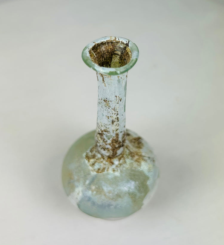 Overhead view of Roman glass bottle revealing narrow mouth, circular opening, and internal residue.