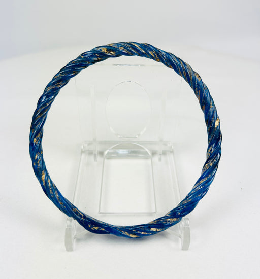Ancient Roman glass bracelet photographed with visible iridescent sheen and smooth rounded edges.