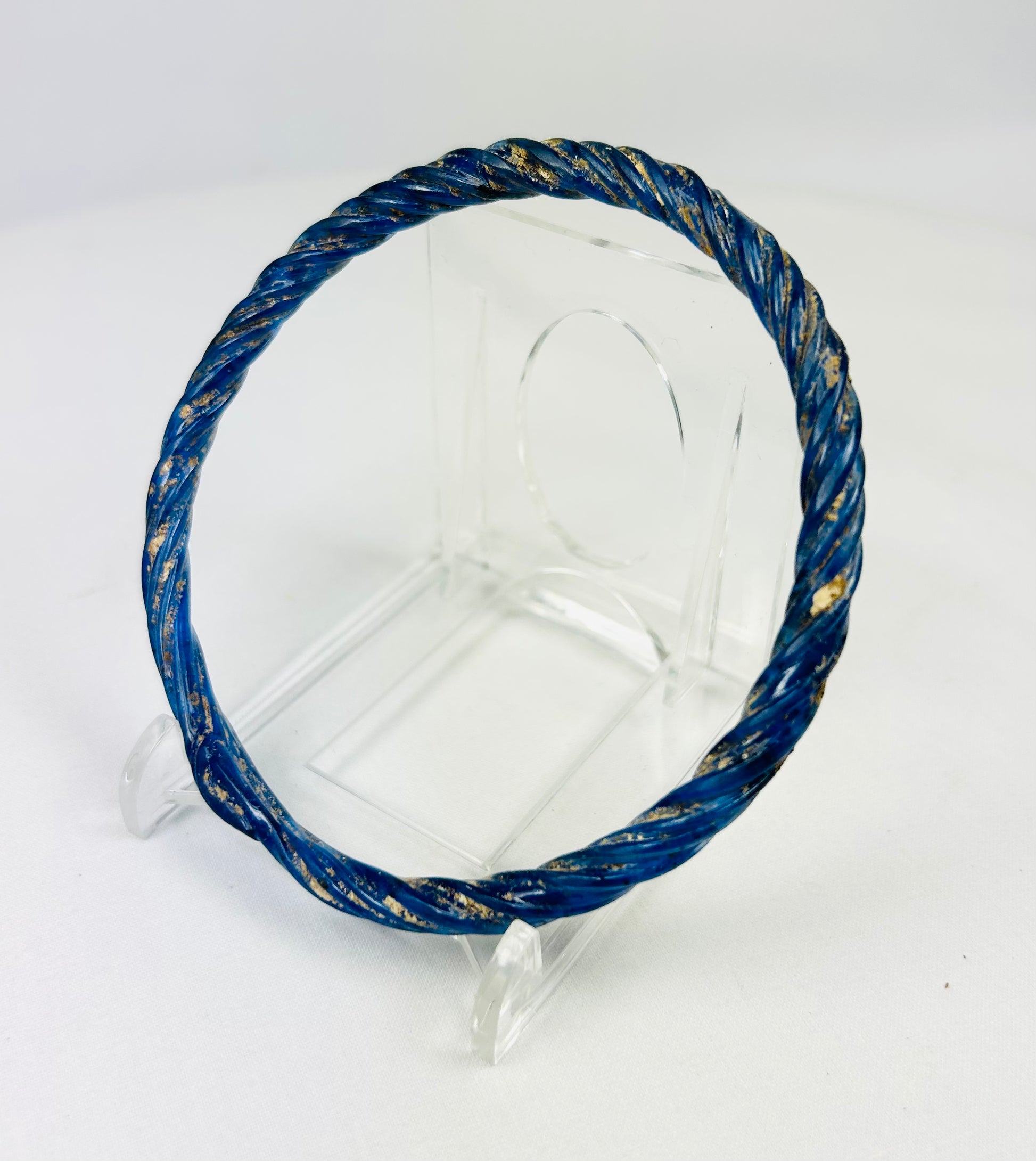 Angled left view of Roman glass bracelet highlighting twisted pattern and deep cobalt-blue coloration.
