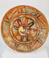 Front view of Mesoamerican polychrome earthenware plate showing central stylized animal design and red-black-cream pigment patterning.