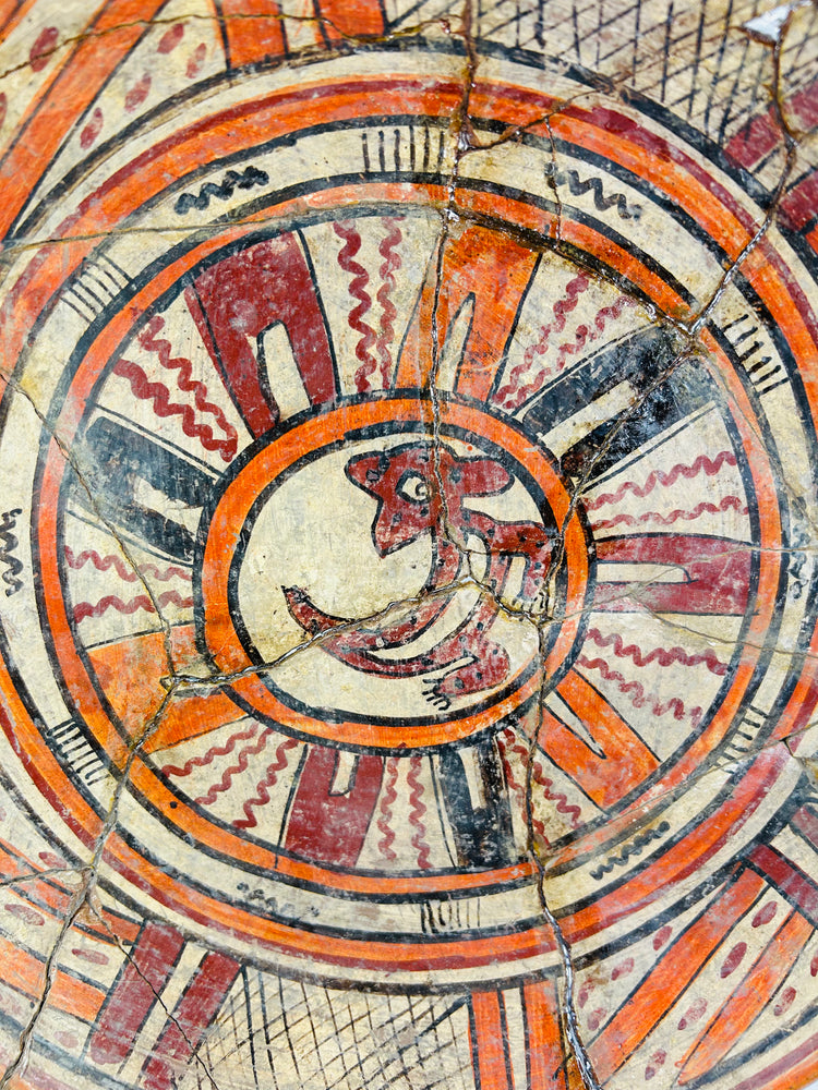 Close-up of zoomorphic center motif on ancient Mesoamerican plate, highlighting fine brushwork and mineral patina.