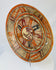 Left-side oblique angle of ancient Mesoamerican polychrome plate showing curvature and painted rim motifs.