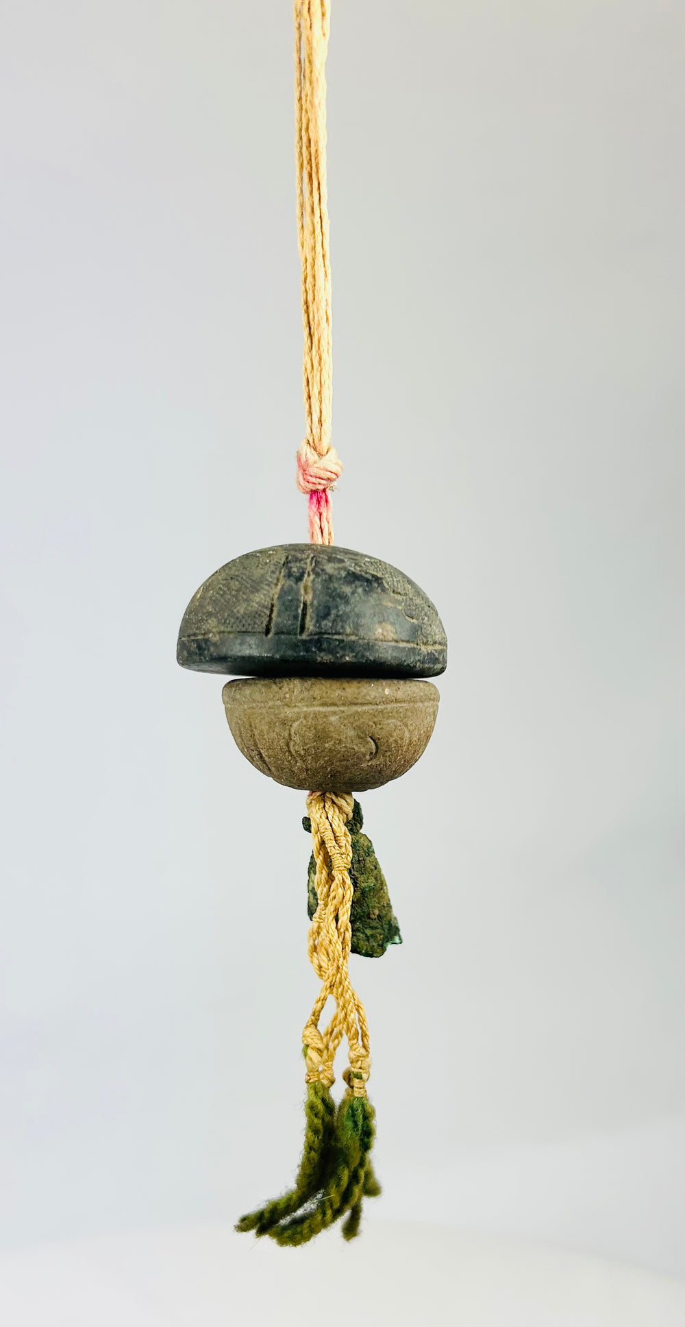 Macro detail of ancient bronze bell surface showing textured verdigris patina and fine tooling marks.