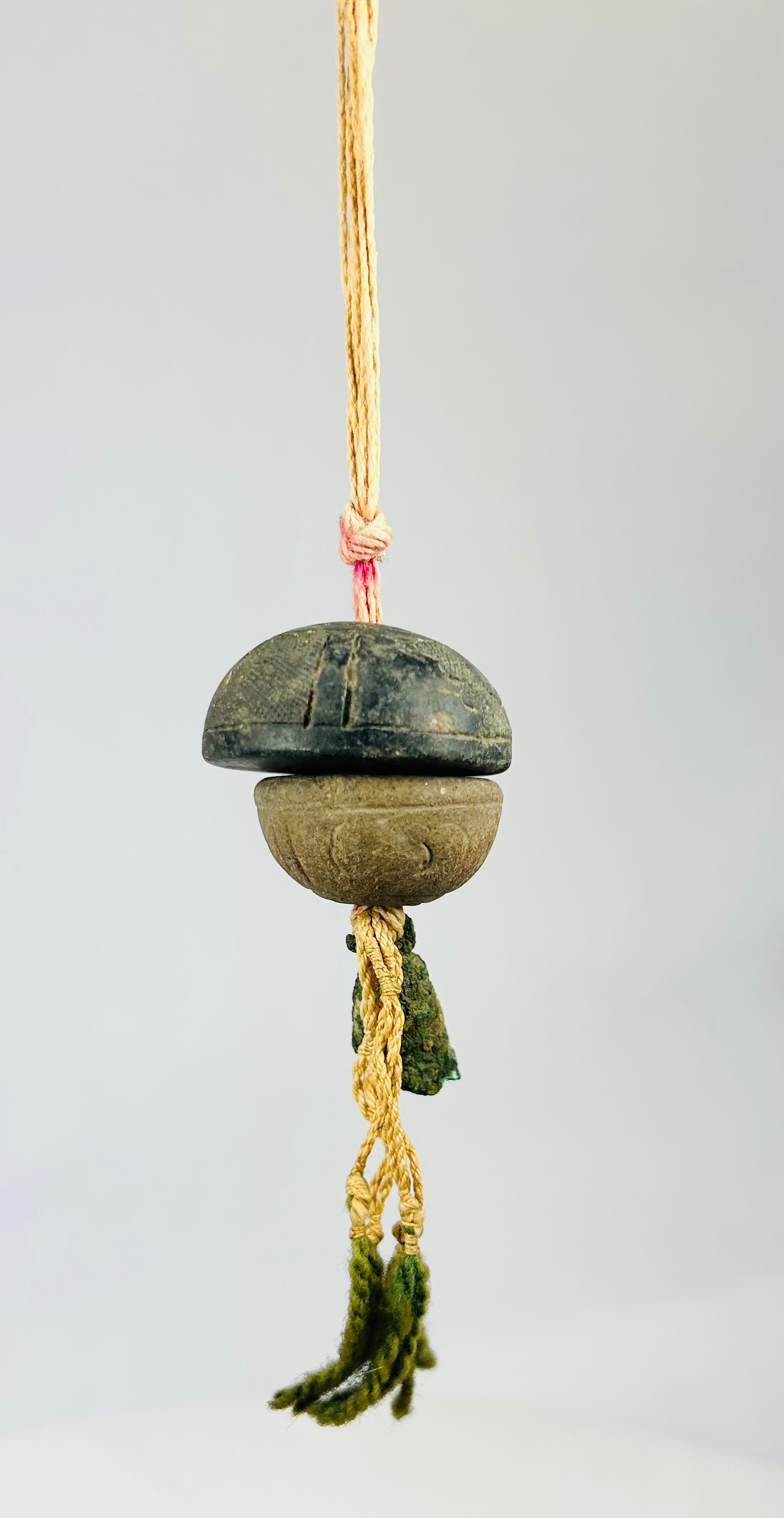 Macro detail of ancient bronze bell surface showing textured verdigris patina and fine tooling marks.