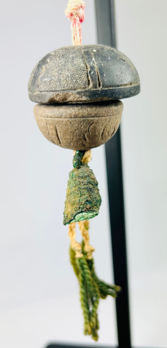 Side profile of bronze ritual bell showing smooth curvature and patinated surface details