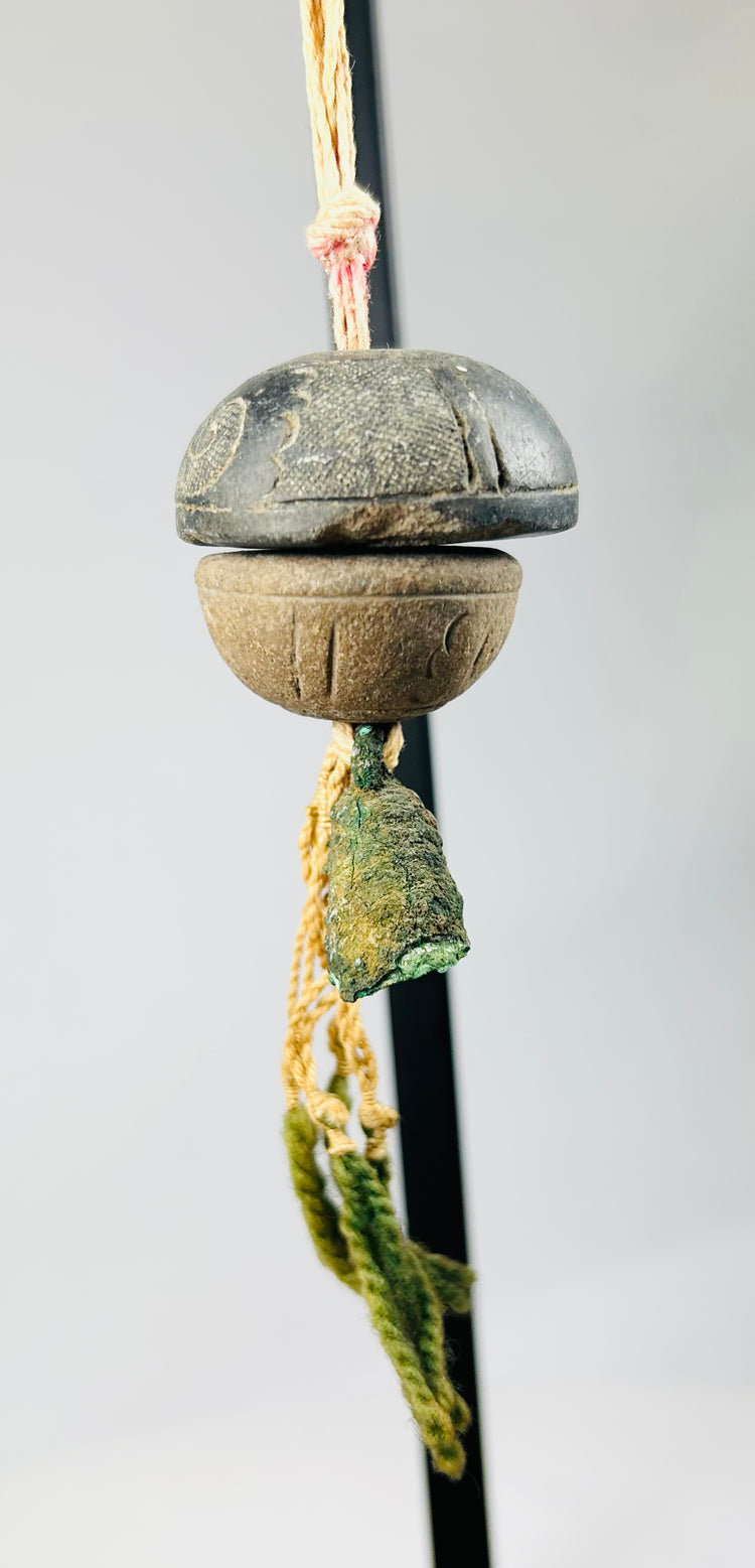 Ancient bronze bell viewed from above, showing internal clapper and natural corrosion pattern.