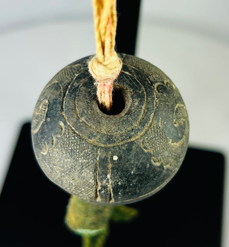 Ancient bronze bell viewed from above, showing internal clapper and natural corrosion pattern