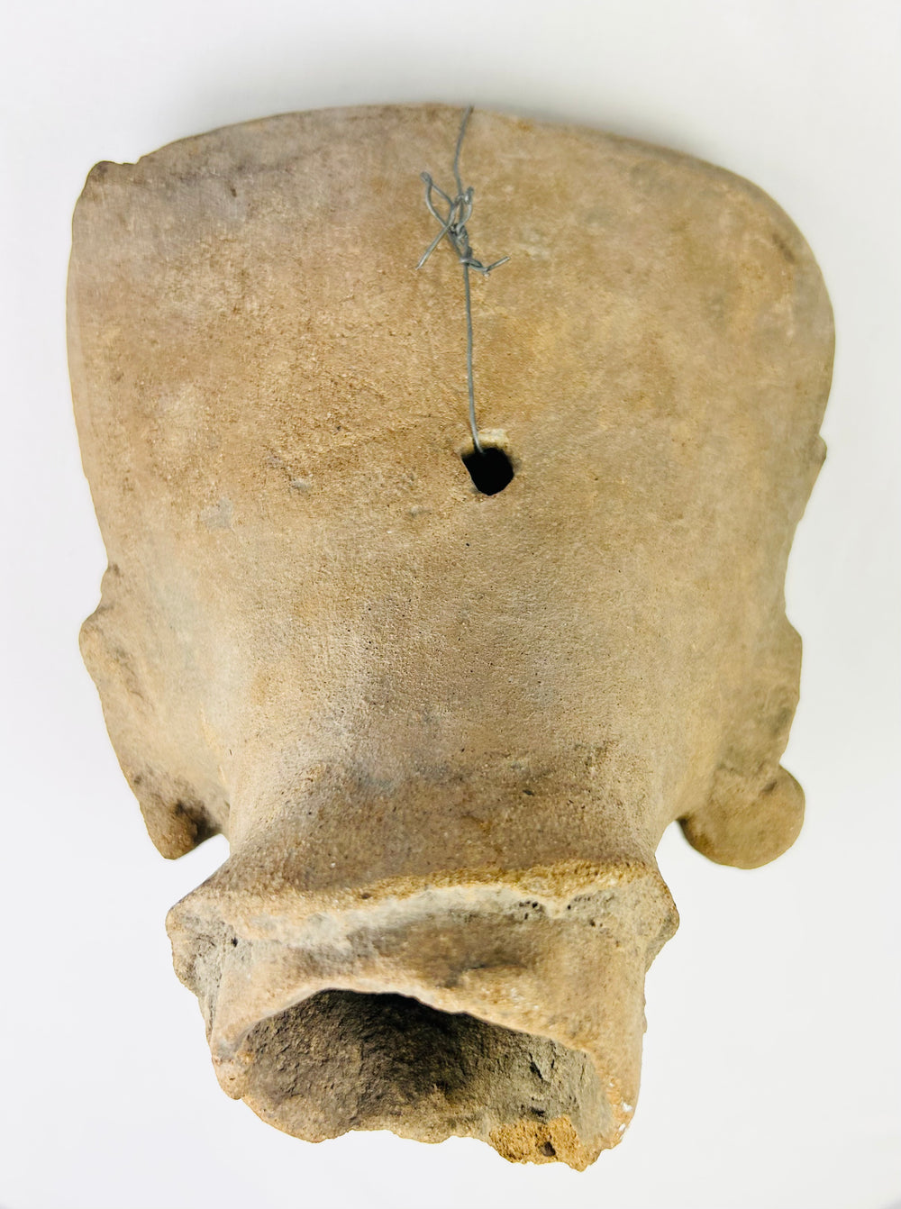 Rear view of the terracotta head fragment showing hollow core and ancient drill aperture