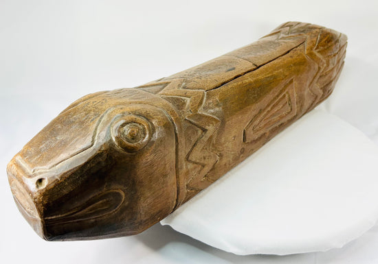 Close-up of antique wooden fish drum highlighting carved eye and mouth details with visible patina.