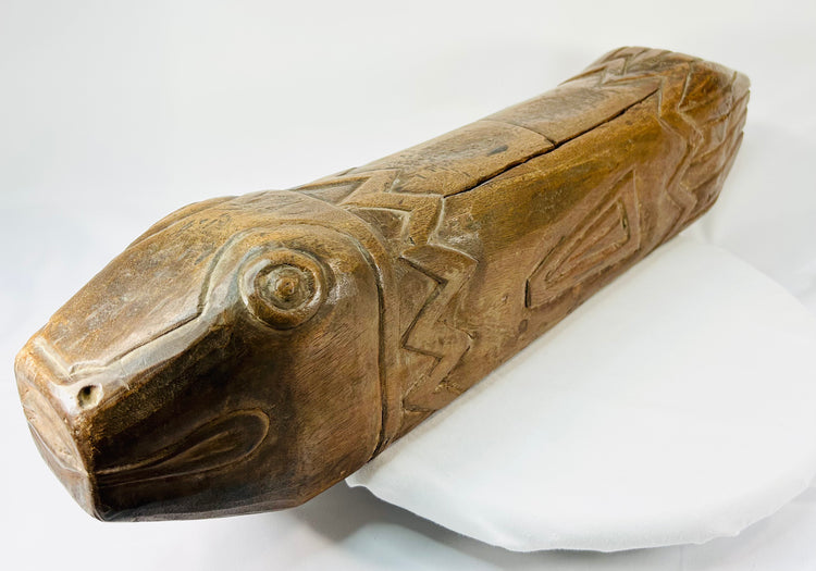 Close-up of antique wooden fish drum highlighting carved eye and mouth details with visible patina.