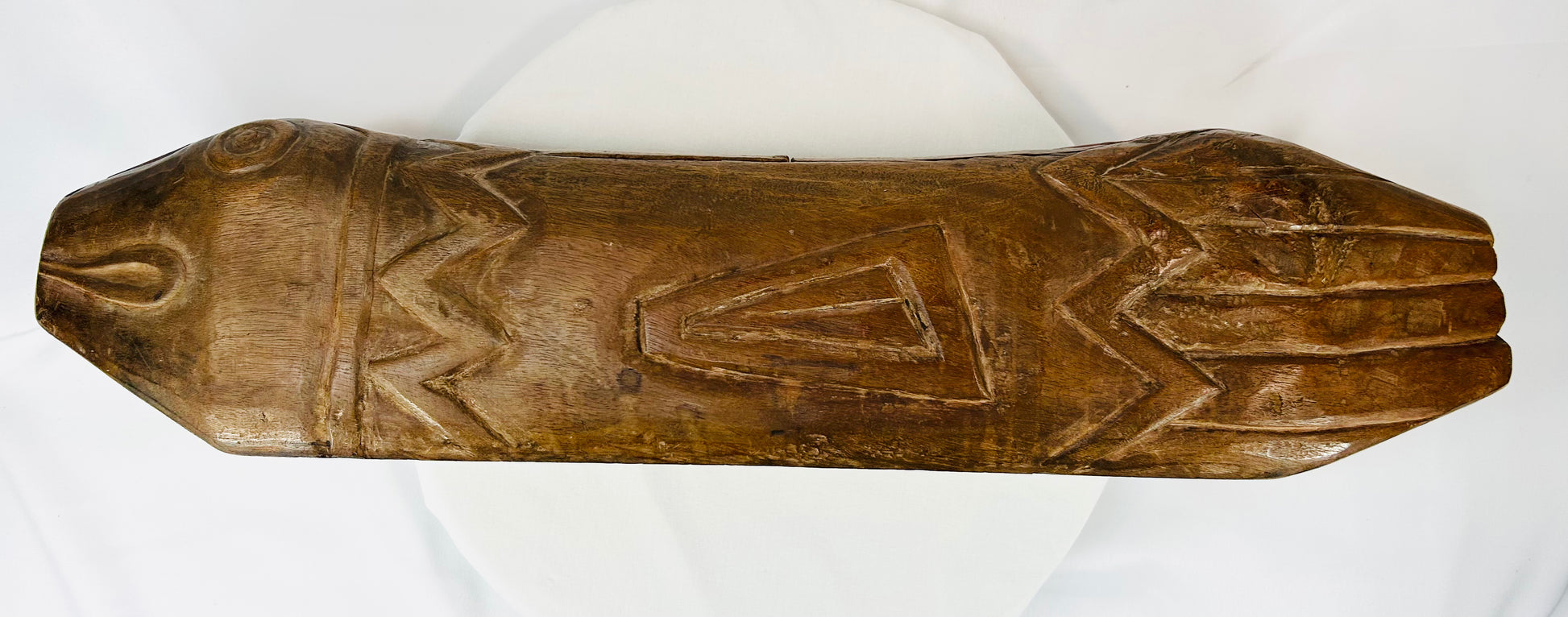 Flat top perspective of carved fish drum revealing surface patterns and triangular engravings