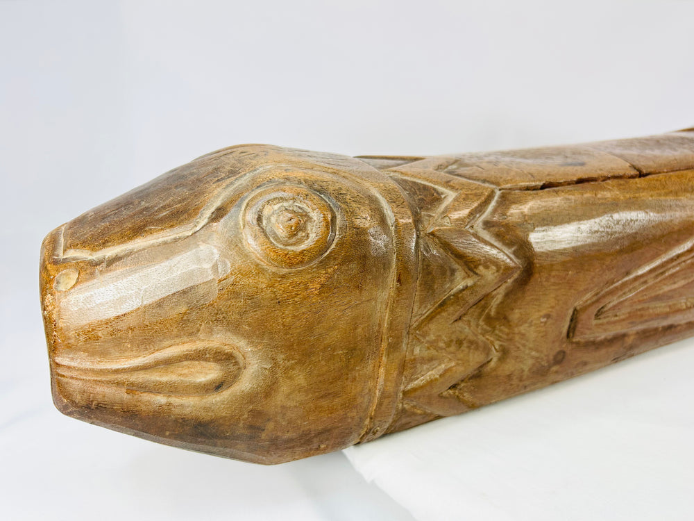 Angled close-up of fish head with defined carvings and smooth weathered texture.