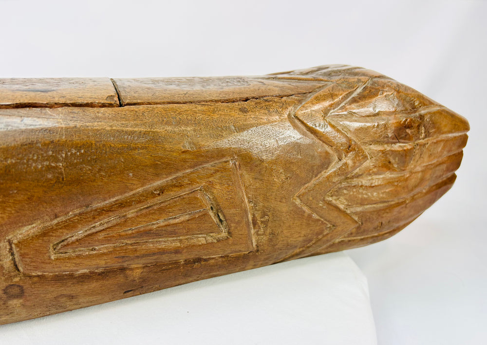 Rear section detail of carved wooden fish drum with zigzag tribal motifs and deep patina.