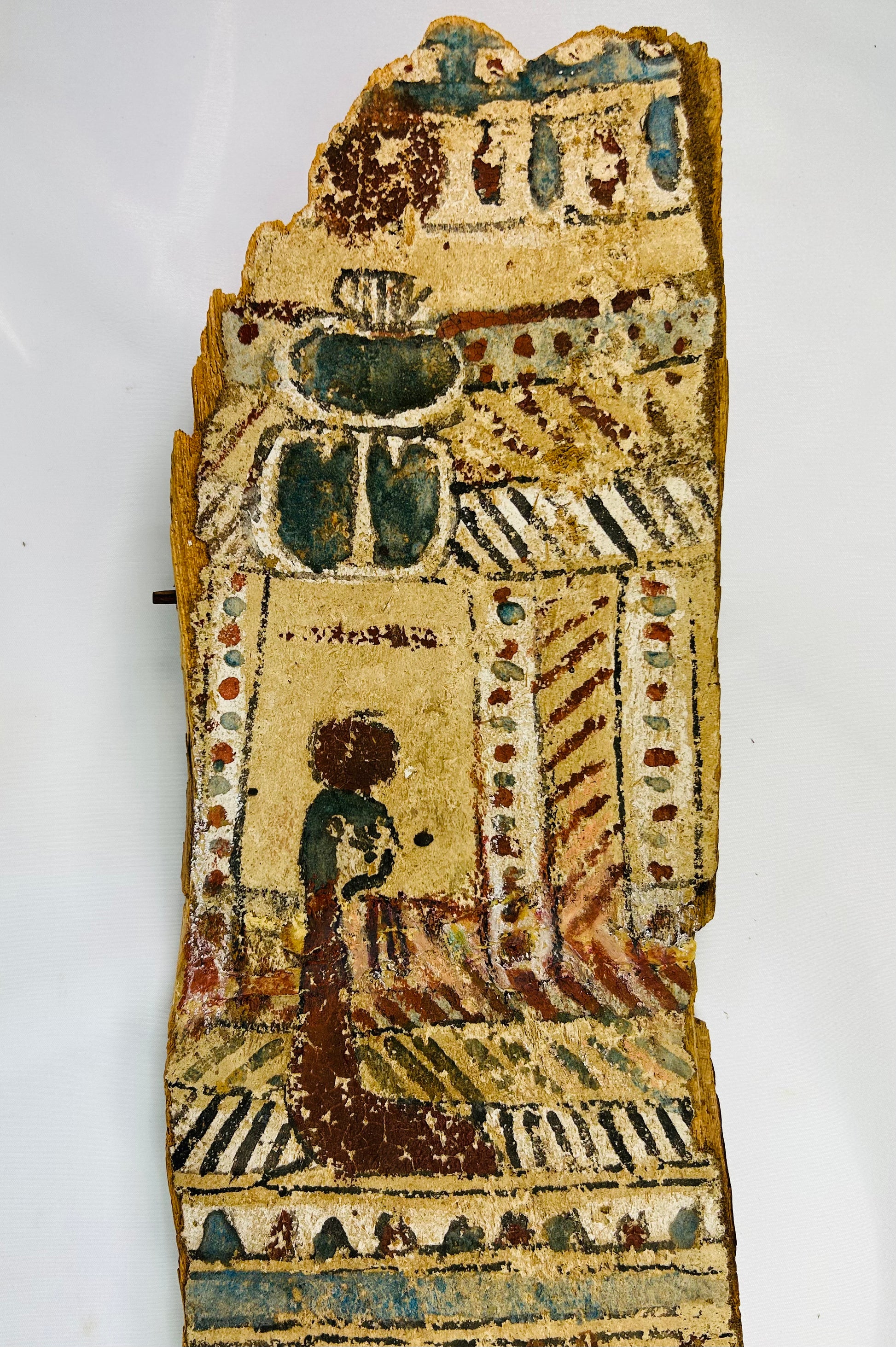 Upper section close-up of coffin panel with large blue-green scarab and kneeling figure before shrine