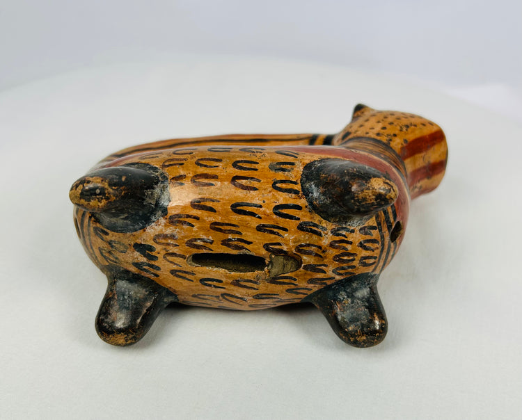 Underside view of Pre-Columbian ceramic rattle vessel showing vent aperture and feline form, Nicoya region