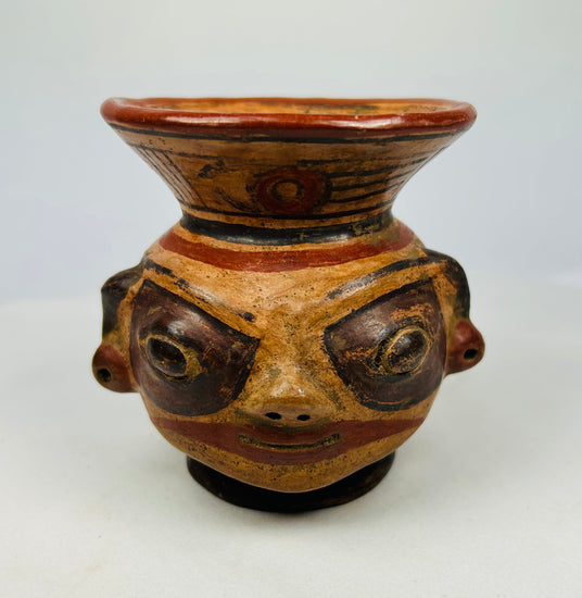 Close-up of Nicoya effigy vessel face with painted eyes, pierced ears, and mineral pigment highlights