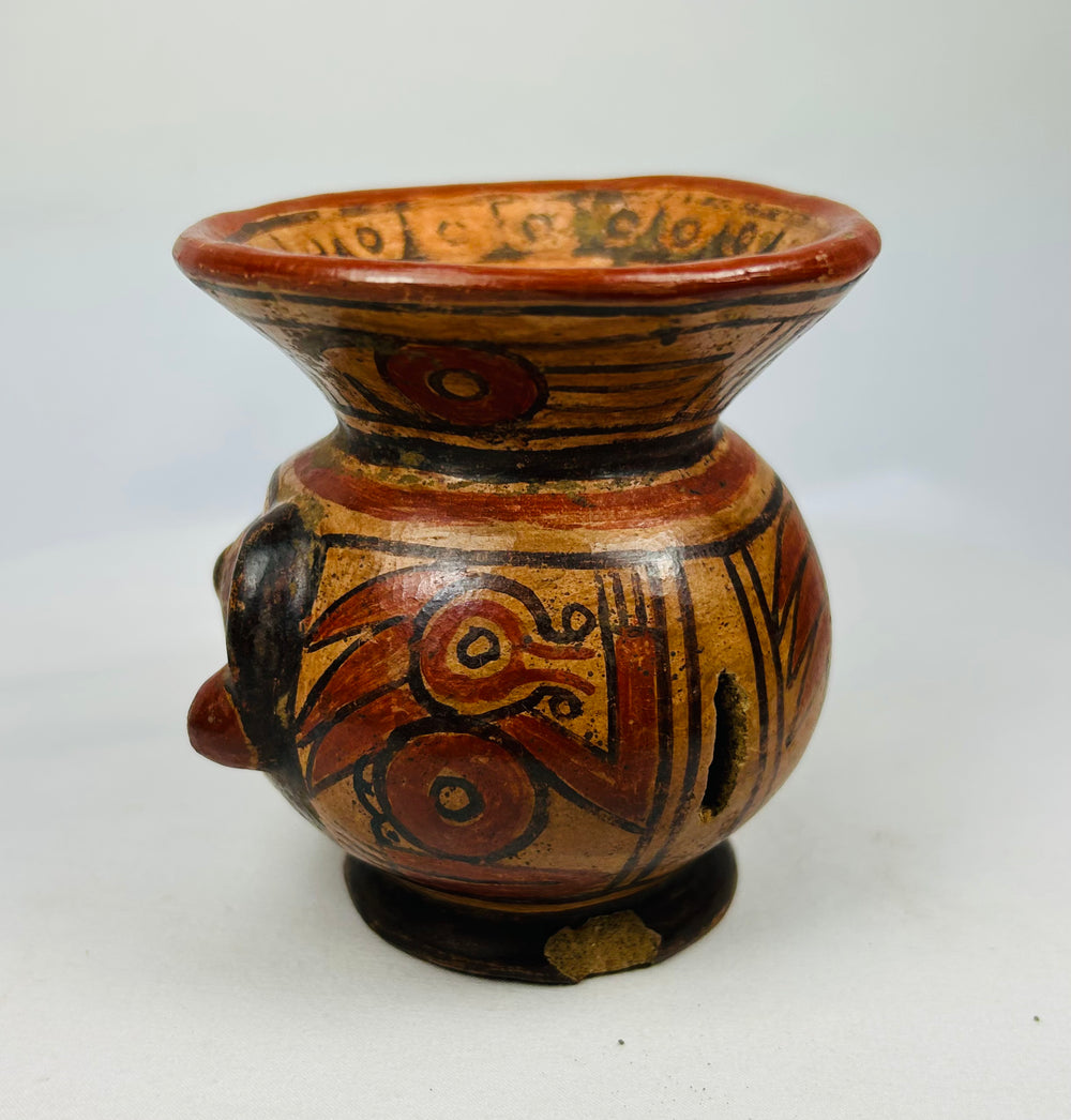 Left side of Guanacaste-Nicoya human-head effigy bowl showing painted cheek and decorative rim band