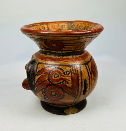 Left side of Guanacaste-Nicoya human-head effigy bowl showing painted cheek and decorative rim band