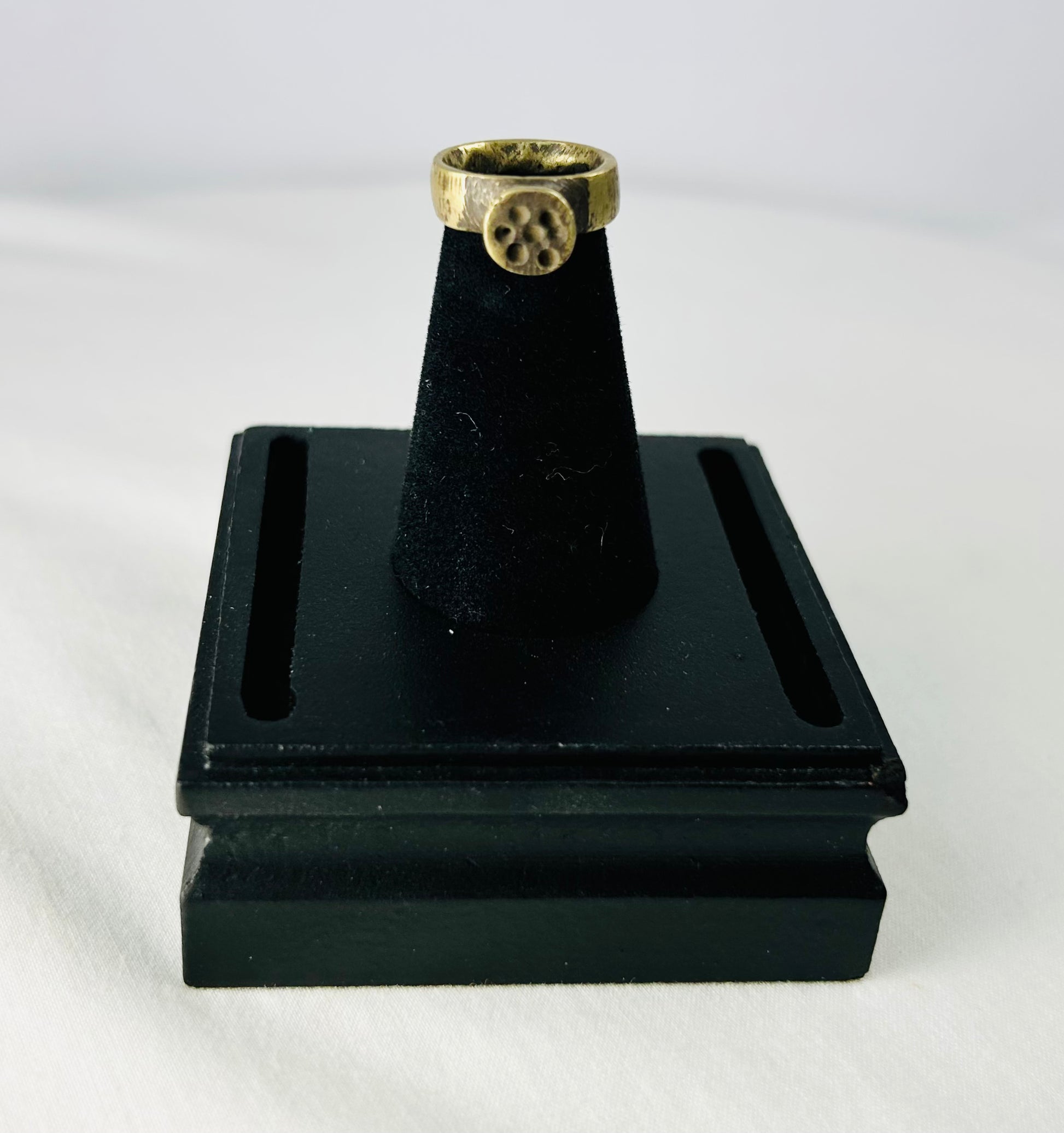 Angled macro photograph showing fine casting details and mineral surface deposits on Roman ring.