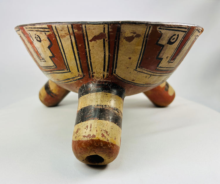 Side profile of rattle tripod vessel emphasizing rim decorations with stylized avian or serpent figures.