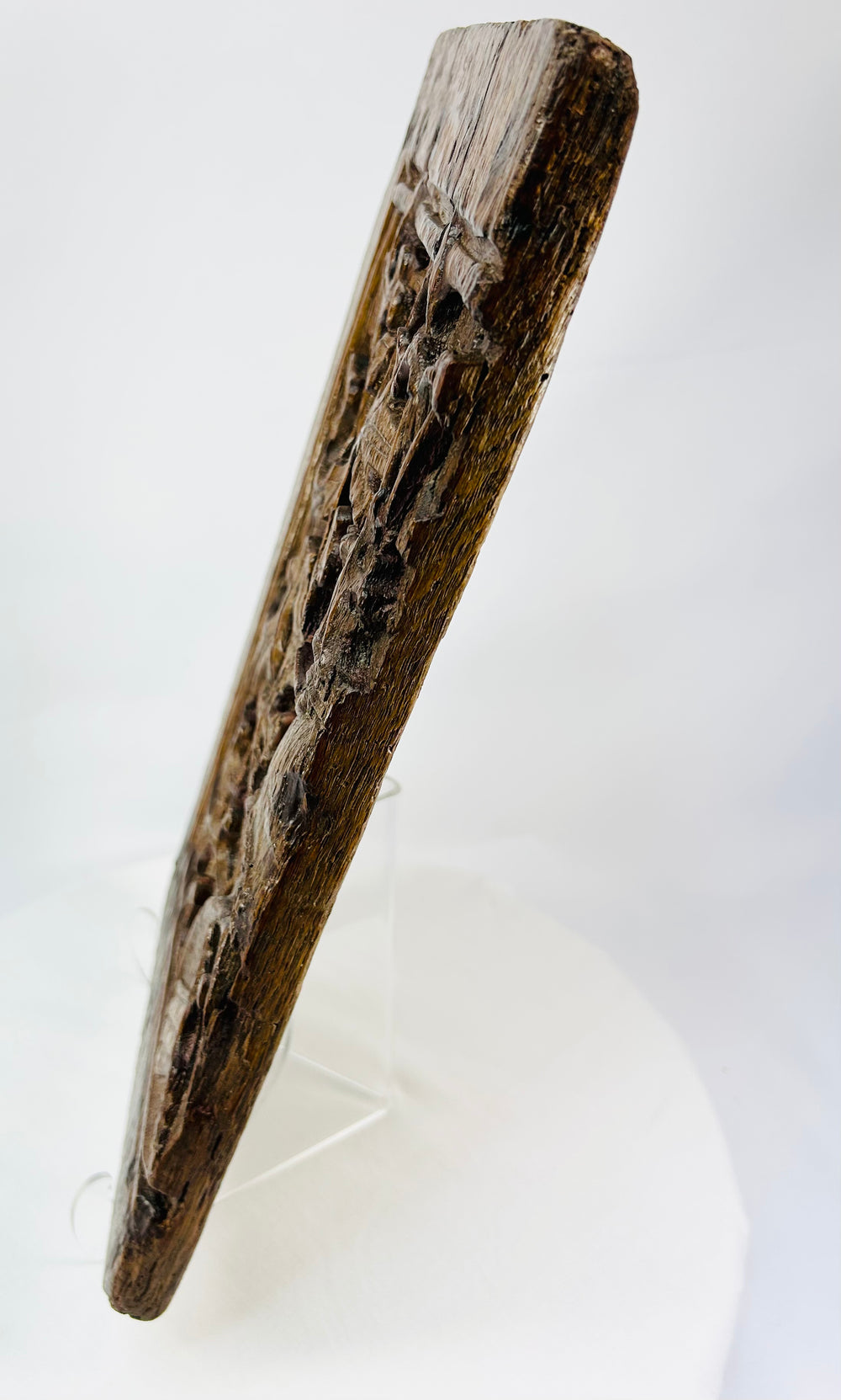 Side view of medieval carved panel revealing depth of relief and remnants of original gilt and pigment.