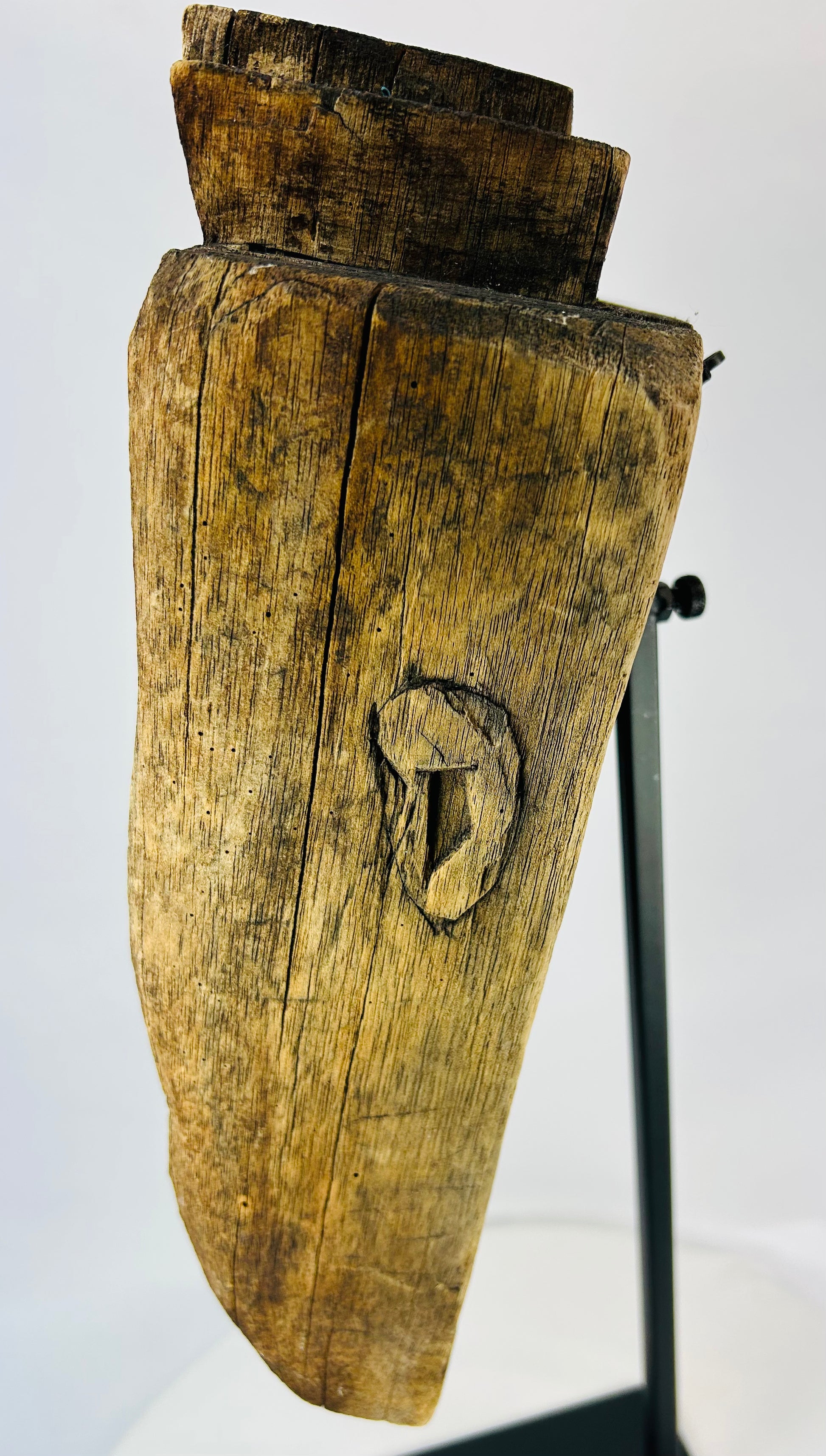 Profile view of ethnographic ritual mask emphasizing wood grain, aged texture, and ceremonial wear.