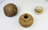 Collection of ancient Asian artifacts including rounded stone object, terracotta oil jar, and pedestal cup with green glaze.