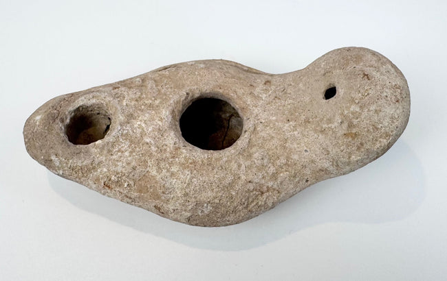 Ancient hand-formed oil lamp made from pale buff terracotta