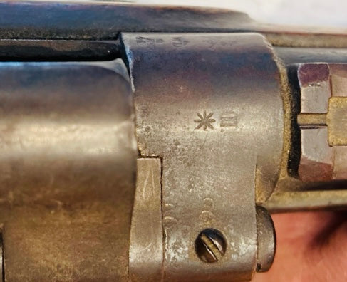 Close-up of engraved proof marks on the metal receiver of a Victorian-era Enfield Snider Conversion rifle.