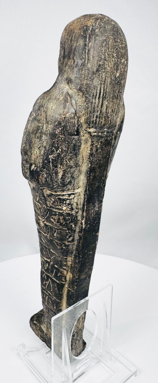 Detailed view of the upper body and vertically striated wig of an ancient Egyptian shabti