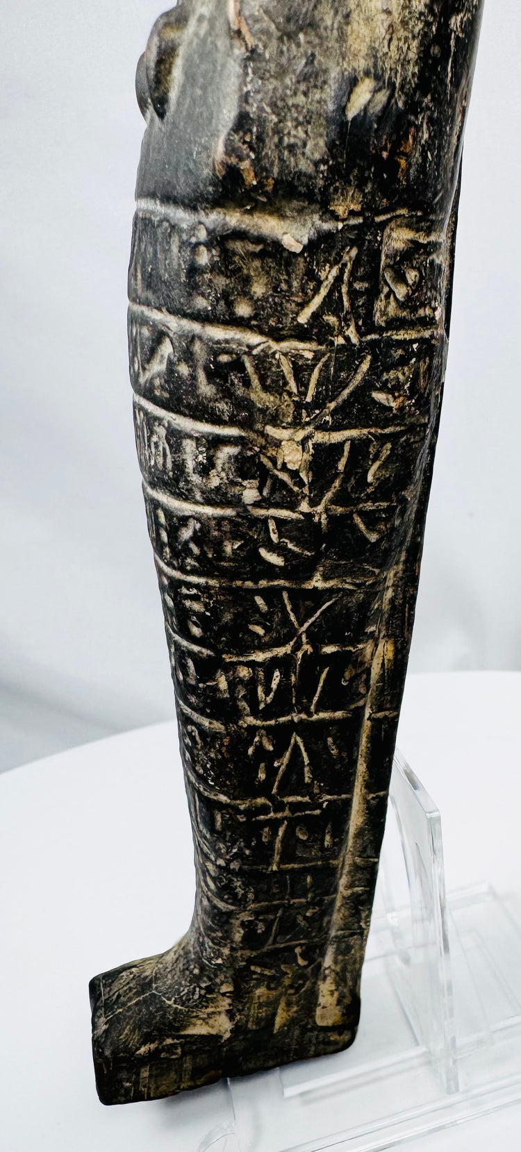 Close-up of ancient Egyptian hieroglyphs carved across the front of a circa 700–600 BCE shabti